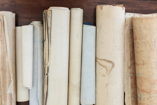 Antique scrolls lined up on a table.