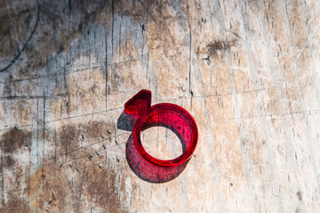 Modern red acrylic ring with diamond shape on distressed wooden table 