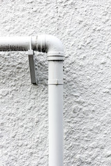 白い外壁とパイプ管