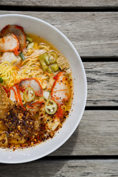 Closeup spicy egg noodle soup on wood background
