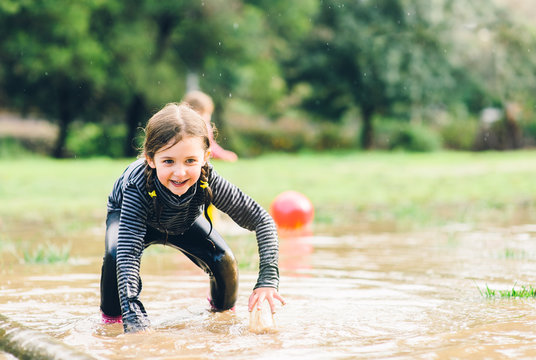 Little Girl Getting Up After Falling In A Big Puddle