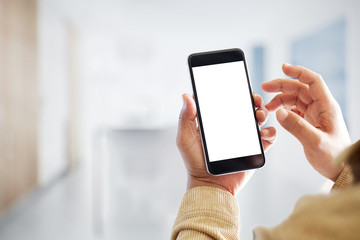 Mock up smartphone blank screen in man hands in blurred office interior background.