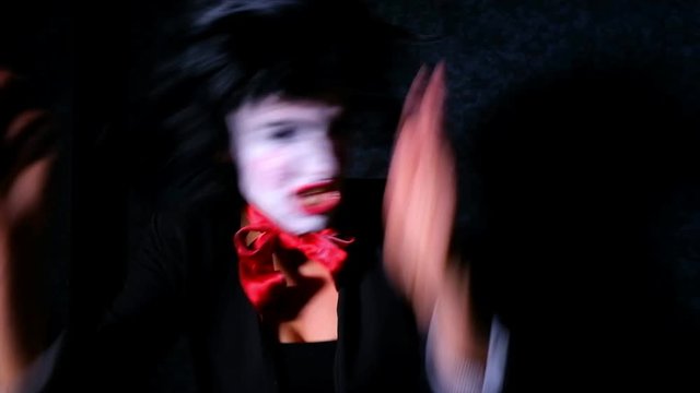 Mad girl dancing, shakes her head and screams on black background