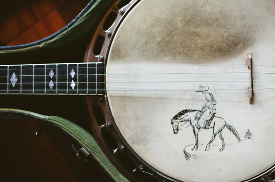 vintage banjo with hand drawn image, sitting in case