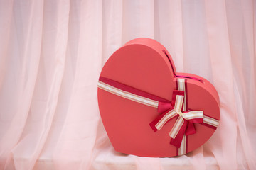 Decorative heart made of cardboard on the background draped in pink
