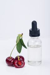 aroma and flavor enhancer next to a ripe cherry, on a white background