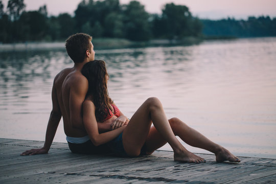 Young couple sitting on the pier