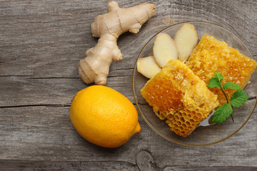 healthy background. honey, honeycomb, lemon, ginger on old wooden table. Top view with copy space