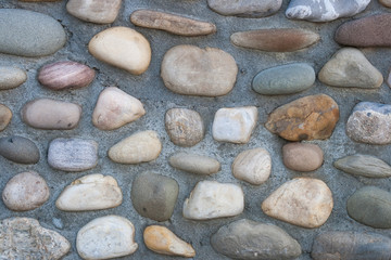 Wall with large pebbles/stones embedded in cement.