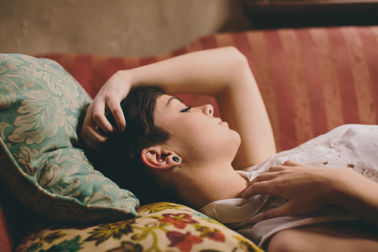 Closeup of a beautiful girl lying on vintage couch with her eyes closed