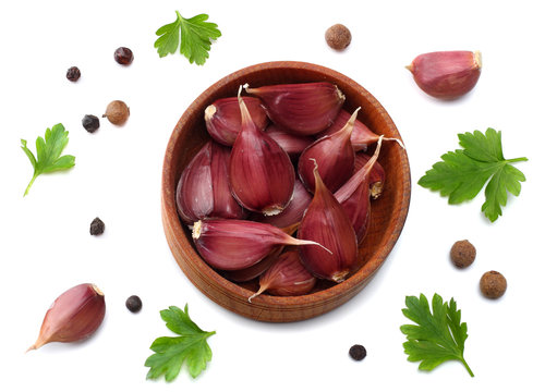 garlic in wooden bowl, parsley and spices isolated on white background. top view