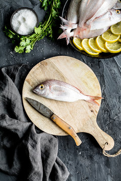 Sea bream on a cutboard with some ingredients