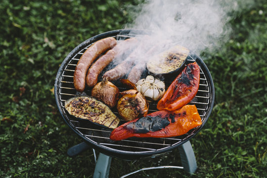 Sausages and vegetables roasting over barbecue