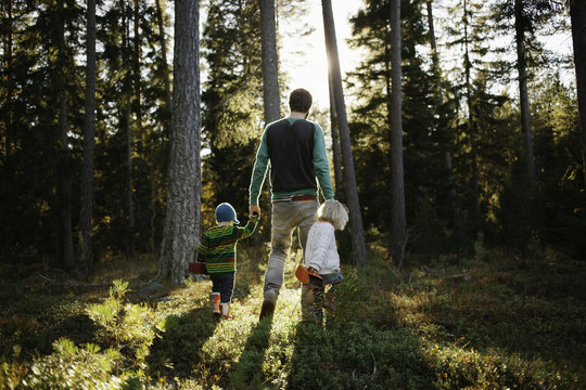 Young family walking through the forest in Sweden.