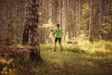 Fototapeta premium Jogging man running in park in sunshine on beautiful summer day. Sport fitness model of Caucasian ethnicity training outdoor for marathon