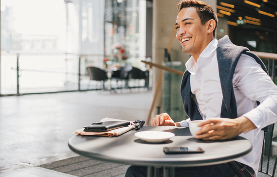 Smiling businessman working from a coffeeshop