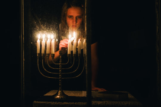 lighting candle in a menorah for Chanukah