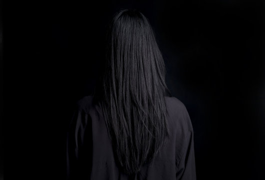 Capelli lunghi e neri su sfondo nero