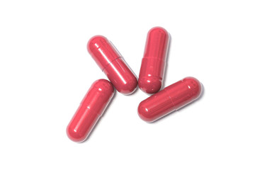 Red color pills capsules on white background