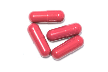Red color pills capsules on white background
