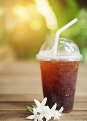 Cold iced black coffee on wooden background.
