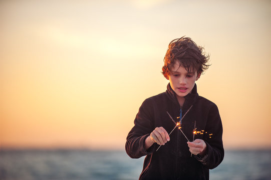Boy playing with sparklers at the beach