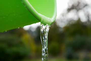 Green bucket and pouring water.
