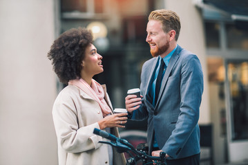 Two mixed race business people talking outside company with holding coffee break relaxing time concept.