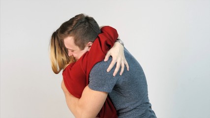 Cheerful couple hugging isolated on white background. Happy couple hugging on the white background. Guy hugging a girl