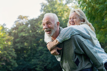 Happy senior couple smiling outdoors in nature  - obrazy, fototapety, plakaty
