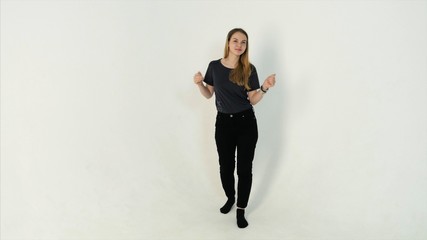 Obraz premium Beautiful fashion woman dancing - isolated over a white background. Happy beautiful girl dancing and celebrating standing in full length, isolated on white background