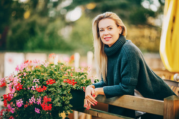 Outdoor portrait of beautiful woman with long blond hair, wearing warm blue pullover