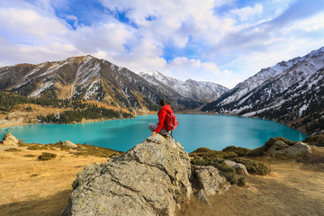 girl sitting on a mountain, mountain lake,Big Almaty Lake, Kazakhstan, Almaty