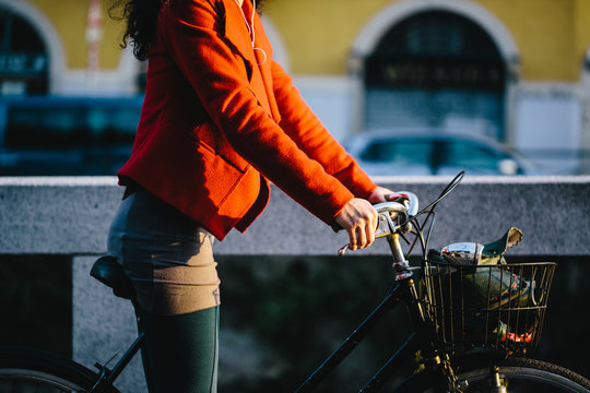 Young woman on a bicycle along the canals of Milan.