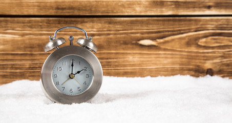 Fototapeta na wymiar clock with snow panorama wintertime change