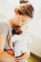Happy young mother with newborn baby in hospital after giving birth