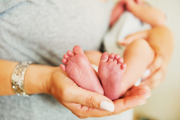 Close up image of baby's feet holding by a mother