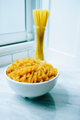spaghetti and pasta bowl and put on the table by the window in the kitchen area in a beautiful house.