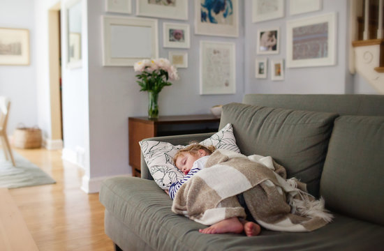 little girl taking a nap on her living room couch
