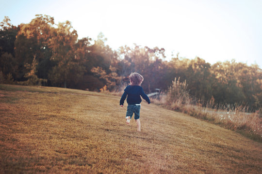 Young Boy Running Barefoot on the Grass
