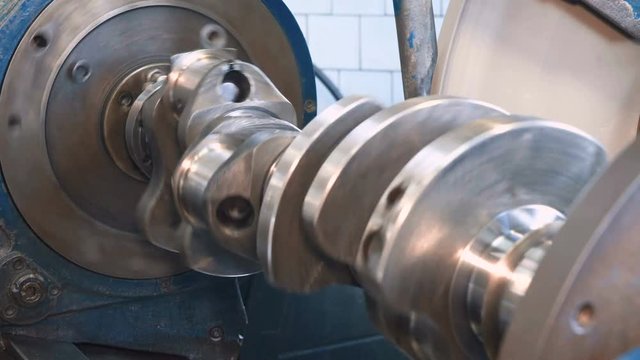 Close up of grinding of crankshaft on a grinding machine. Shot with Sony a7s and Atomos Ninja Flame in car service, dolly slide.