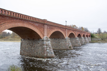 Obraz premium old Brick bridge across the River Venta in the city of Kuldiga Latvia