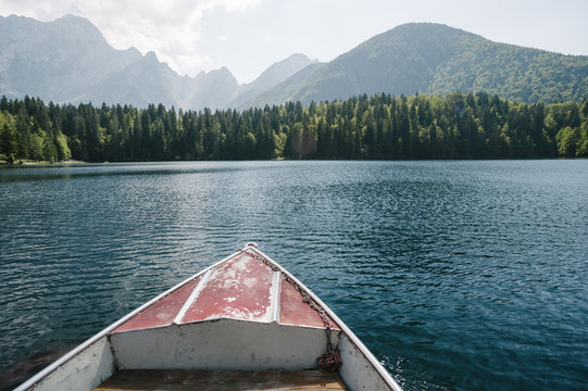 Wooden boat crossing a mountain lake