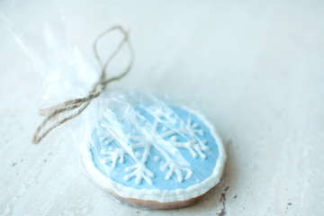 A Christmas gingerbread cookie in the shape of a blue round snowflake close-up. Selective focus, bokeh.