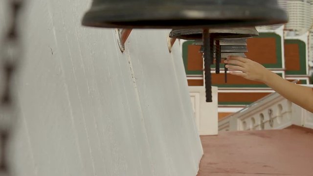 Woman ring sacral bells in Wat Saket Ratcha Wora Maha Wihan (the Golden Mount) . Bangkok Thailand.