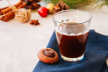 Glass of coffee and thumbprint cookies on a white background.
