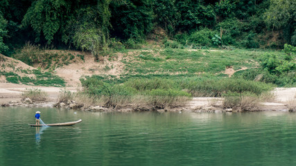 Fisherman in fishing boat in a river in Vietnam