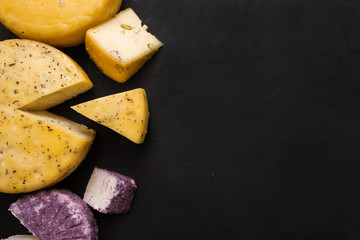 Assortment of dairy handmade milk products, top view and free space. Quality sorts of winery cheese and Caciotta with herbs and pistachio, traditional cuisine and healthy food concept