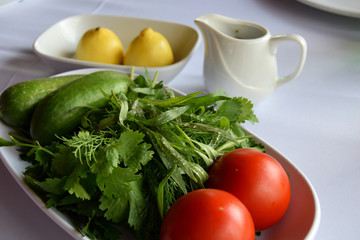 Traditional plate with fresh tomatoes, cucumbers and greens in Azerbaijan