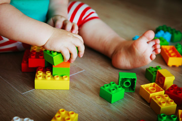 little baby playing with colorful plastic blocks